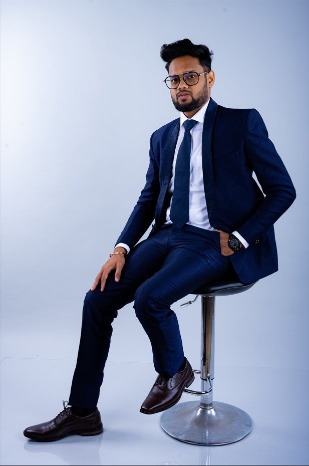 Naman Nandurkar, Founder and CEO of Octmi, seated on a tall stool during a studio portrait shoot